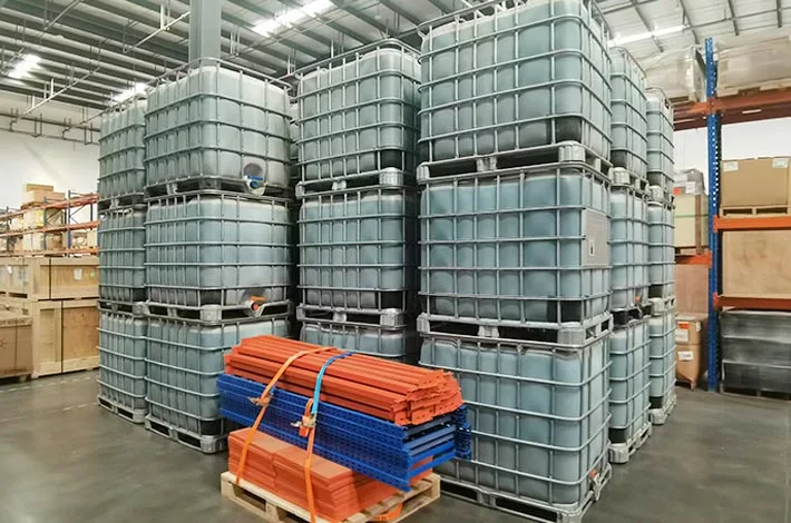 Stacked IBC containers and warehouse shelving inside a storage facility