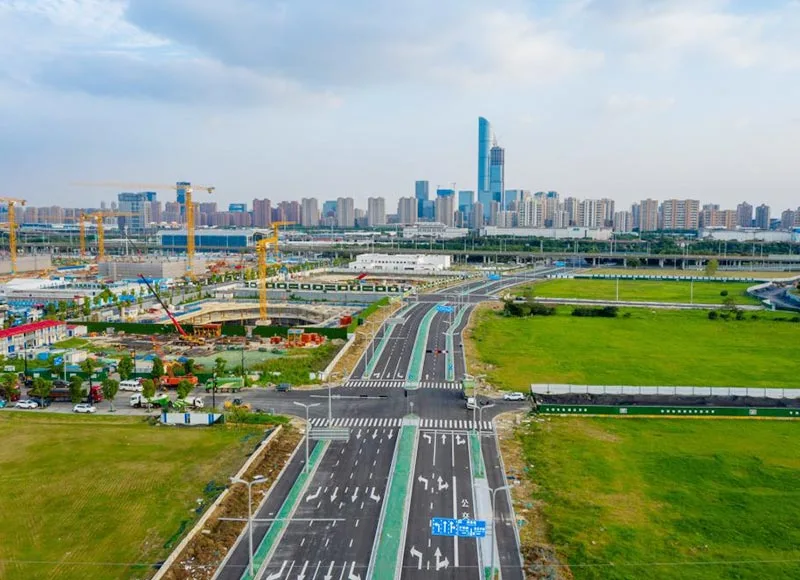 Aerial view of paved roads and an intersection beside an urban construction site