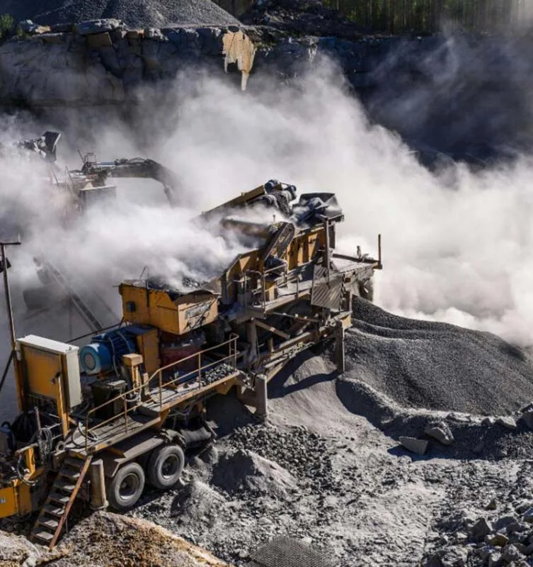 Dust rising from mobile crushing and screening equipment at a quarry
