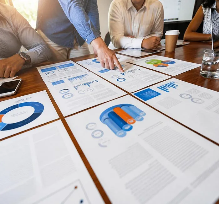 Team reviewing printed charts and documents during a meeting