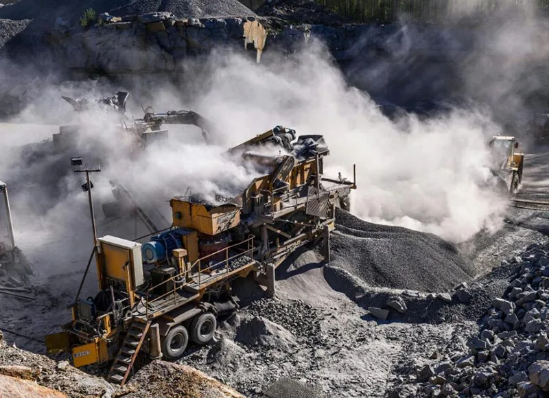 Dust rising from mobile crushing and screening equipment at a quarry