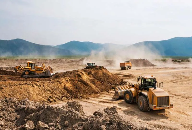 Wheel loader, bulldozer and haul truck working at a dusty earthworks site